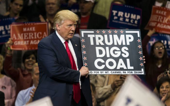 Trump segurando placa a favor da industria carvão
